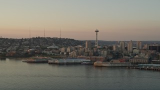 AX50_011 - 5K aerial stock footage reverse view of the Seattle Space Needle and Central Waterfront piers at sunset, Downtown Seattle, Washington