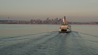 AX50_016 - 5K aerial stock footage fly low by a ferry sailing Elliott Bay to reveal Downtown Seattle skyline, Washington, sunset