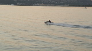 AX50_036 - 5K aerial stock footage of tracking a speedboat cruising across Elliott Bay, Seattle, Washington, sunset