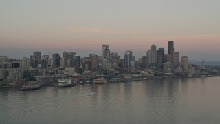 AX50_039 - 5K aerial stock footage of Central Waterfront and the Downtown Seattle skyline seen from Elliott Bay, Washington, sunset