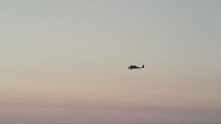AX50_040 - 5K aerial stock footage of tracking a Blackhawk helicopter at sunset, Seattle, Washington