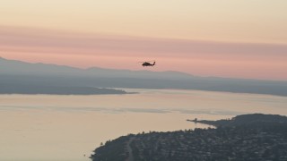 AX50_041 - 5K aerial stock footage of tracking a helicopter over Puget Sound, Washington, sunset