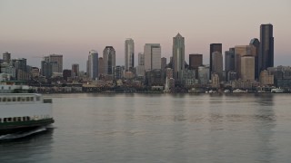 AX50_044 - 5K aerial stock footage track a ferry sailing Elliott Bay and reveal the Downtown Seattle skyline in Washington, sunset