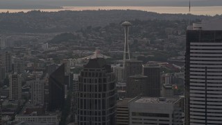 AX50_052E - 5K aerial stock footage of Seattle Space Needle seen while passing tall skyscrapers in Downtown Seattle, Washington, sunset