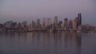 AX50_072 - 5K aerial stock footage of a view across Elliott Bay at the Downtown Seattle skyline and Central Waterfront, Washington, sunset