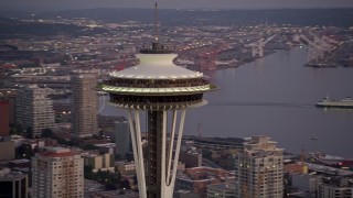 AX50_075E - 5K aerial stock footage orbit the top of the world famous Seattle Space Needle in Downtown Seattle, Washington, sunset