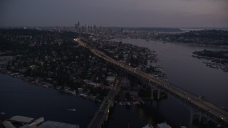 AX50_087 - Aerial stock footage of 5K aerial  video of Ship Canal Bridge, approach Lake Union and the Downtown Seattle skyline, Washington, twilight