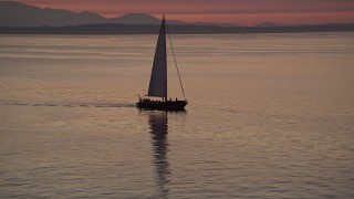 AX50_094 - 5K aerial stock footage video of sailboat on Elliott Bay at sunset, Seattle, Washington