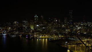 AX51_009 - 5K aerial stock footage of Downtown Seattle skyline, and the Seattle Great Wheel at the Waterfront at night, Washington