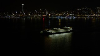 AX51_010 - 5K aerial stock footage orbit ferry sailing Elliott Bay at night, Downtown Seattle skyline in background, Washington