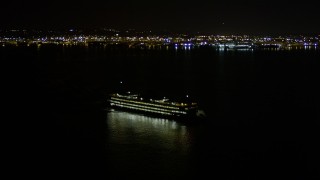 AX51_011 - 5K aerial stock footage track a ferry sailing Elliott Bay and reveal Downtown Seattle skyline, Washington, night