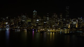 AX51_016E - 5K aerial stock footage of Downtown Seattle skyline and Central Waterfront piers, Washington, night