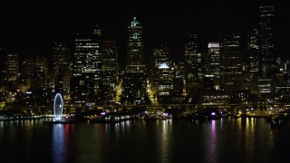 AX51_017 - 5K aerial stock footage of Seattle Great Wheel, Waterfront piers, and the Downtown Seattle skyline, Washington, night