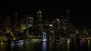AX51_018 - Aerial stock footage of 5K aerial  video of the Seattle Great Wheel and Waterfront piers, and Downtown Seattle skyline in Washington, nighttime