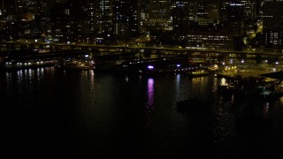 AX51_043E - 5K aerial stock footage of Central Waterfront piers near Seattle Great Wheel in Downtown Seattle, Washington, night