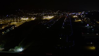 AX51_101E - 5K aerial stock footage approach Renton Municipal Airport runway from Lake Washington, night