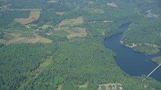 AX52_015 - 5K aerial stock footage of reverse view of farms, fields and trees by Mayfield Lake in Silver Creek, Washington