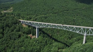 AX52_028E - 5K aerial stock footage orbit Spirit Lake Highway bridge, track an SUV crossing bridge, Cowlitz County, Washington