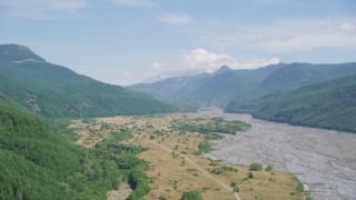 AX52_031 - 5K stock footage aerial video pass a wooded slope to reveal North Fork Toutle River leading to Mount St. Helens, Washington
