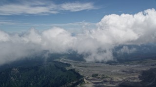 AX52_052 - 5K aerial stock footage fly through clouds to reveal Mount Rainier in the far distance, Washington
