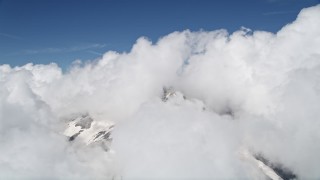 AX52_056 - 5K aerial stock footage of thick clouds atop Mount St. Helens, reveal snowy slopes, Washington