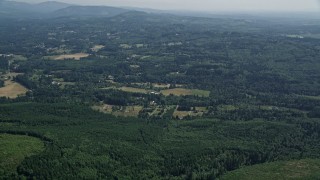 AX52_068 - 5K aerial stock footage of small farms surrounded by evergreen forest, Amboy, Washington