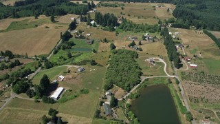 AX52_071E - 5K aerial stock footage of small farms, fields and country roads in La Center, Washington