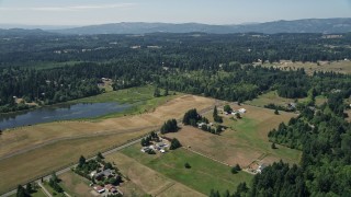 AX52_073 - 5K aerial stock footage of farms and fields near a small pond in La Center, Washington