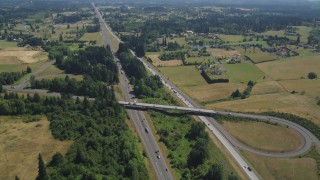 AX52_088 - 5K aerial stock footage of light traffic on I-5 through a rural farm area in Ridgefield, Washington