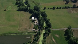 AX52_103 - 5K aerial stock footage of bird's eye view of a farm house and green farm fields in Riverview, Oregon