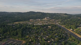 AX54_009E - 5K aerial stock footage of Providence St. Vincent Medical Center, highway interchange, Southwest Portland, Oregon, sunset