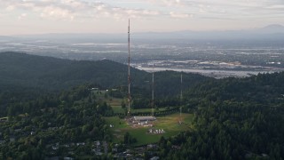 AX54_015 - 5K aerial stock footage of flying by hilltop radio towers in Southwest Portland, Oregon, sunset