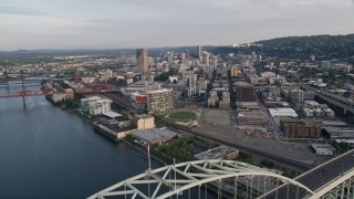 AX54_024 - 5K aerial stock footage of flying over the Fremont Bridge, approaching Downtown Portland, Oregon, sunset