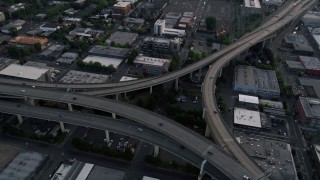 AX54_025 - 5K aerial stock footage tilt to bird's eye of Highway 30 and Interstate 405 interchange, Portland, Oregon, sunset
