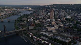 AX54_030 - 5K stock footage aerial video of flying by city bridges across the Willamette River, Downtown Portland, Oregon, sunset