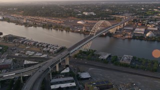 AX54_062E - 5K aerial stock footage of orbiting Fremont Bridge, revealing Downtown Portland, Oregon, sunset