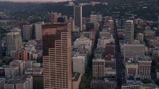 AX54_076 - 5K aerial stock footage of flying by US Bancorp Tower and city streets in Downtown Portland, Oregon, sunset