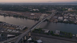 AX54_083E - 5K aerial stock footage of orbiting the top of the Fremont Bridge, Downtown Portland, Oregon, sunset