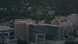 AX54_090 - 5K aerial stock footage of helicopter landing, Oregon Health and Science University, Portland, Oregon, sunset