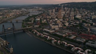 AX54_103E - 5K aerial stock footage of flying by downtown and bridges over the river, Downtown Portland, Oregon, twilight