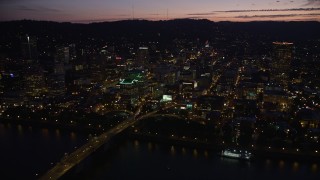 AX55_011E - 5K aerial stock footage fly by buildings in downtown, Morrison and Hawthorne Bridges, Downtown Portland, Oregon, twilight