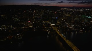 AX55_045E - 5K aerial stock footage of flying over buildings near Wells Fargo Center, Portland, Oregon, night