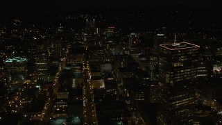 AX55_053E - 5K aerial stock footage of flying by US Bancorp Tower, and toward Wells Fargo Center, Downtown Portland, Oregon, night