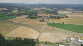 AX56_007 - 5K aerial stock footage approach Highway 26 through farm fields in North Plains, Oregon
