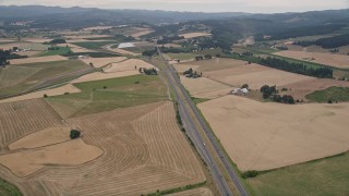 AX56_009 - 5K aerial stock footage of following Highway 26 past farmland to Highway 6 split, Banks, Oregon