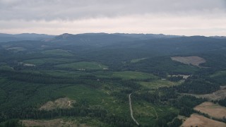 AX56_019 - 5K aerial stock footage pass evergreen forest and wide clear cut areas in Washington County, Oregon