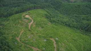 AX56_030 - 5K aerial stock footage of a dirt road in a logging area and evergreen forest in Washington County, Oregon