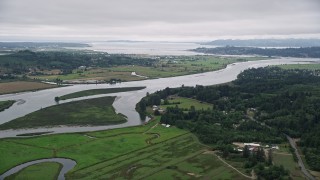 AX56_066E - 5K aerial stock footage approach and pan across the Youngs River with farm fields by the water in Astoria, Oregon