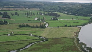 AX56_069 - 5K aerial stock footage of farmland and small creeks beside Youngs River, Astoria, Oregon