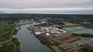 AX56_073 - 5K aerial stock footage of a large lumber mill beside the Skipanon River, Warrenton, Oregon